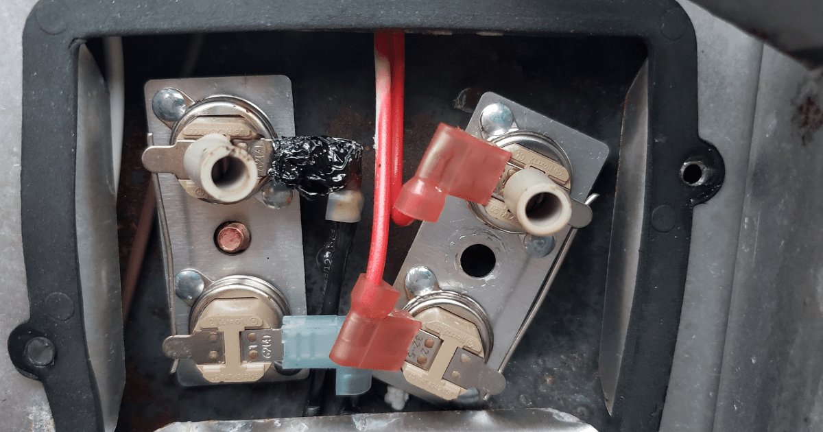 RV shore power cord plugged into a campground pedestal with an electrical management system inline