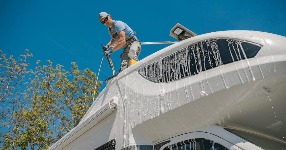 Close-up of an RV roof showing sealant around a vent opening and visible seam lines
