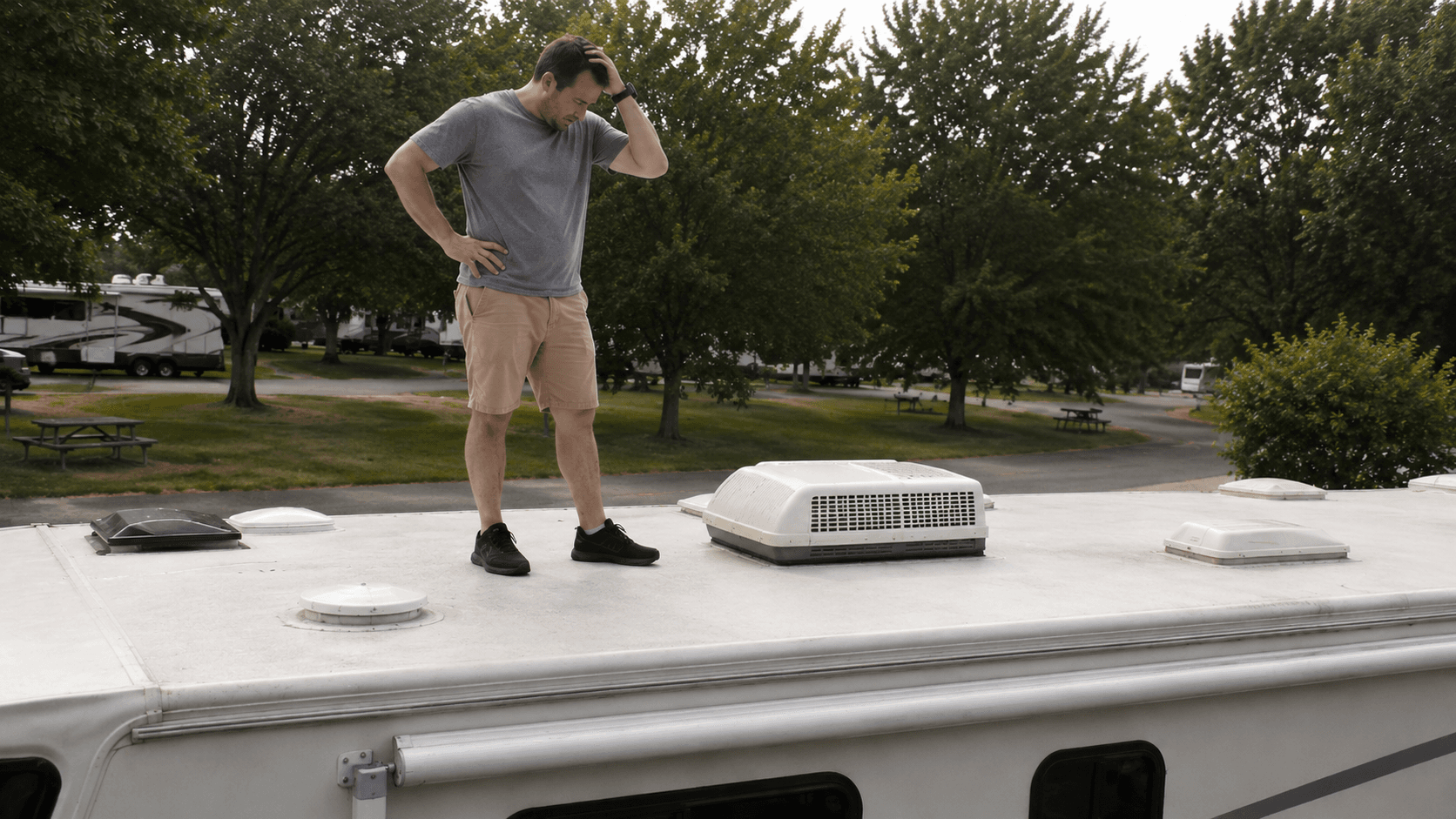 An RV rooftop air conditioner with the shroud removed, showing the coils and filter during a maintenance check